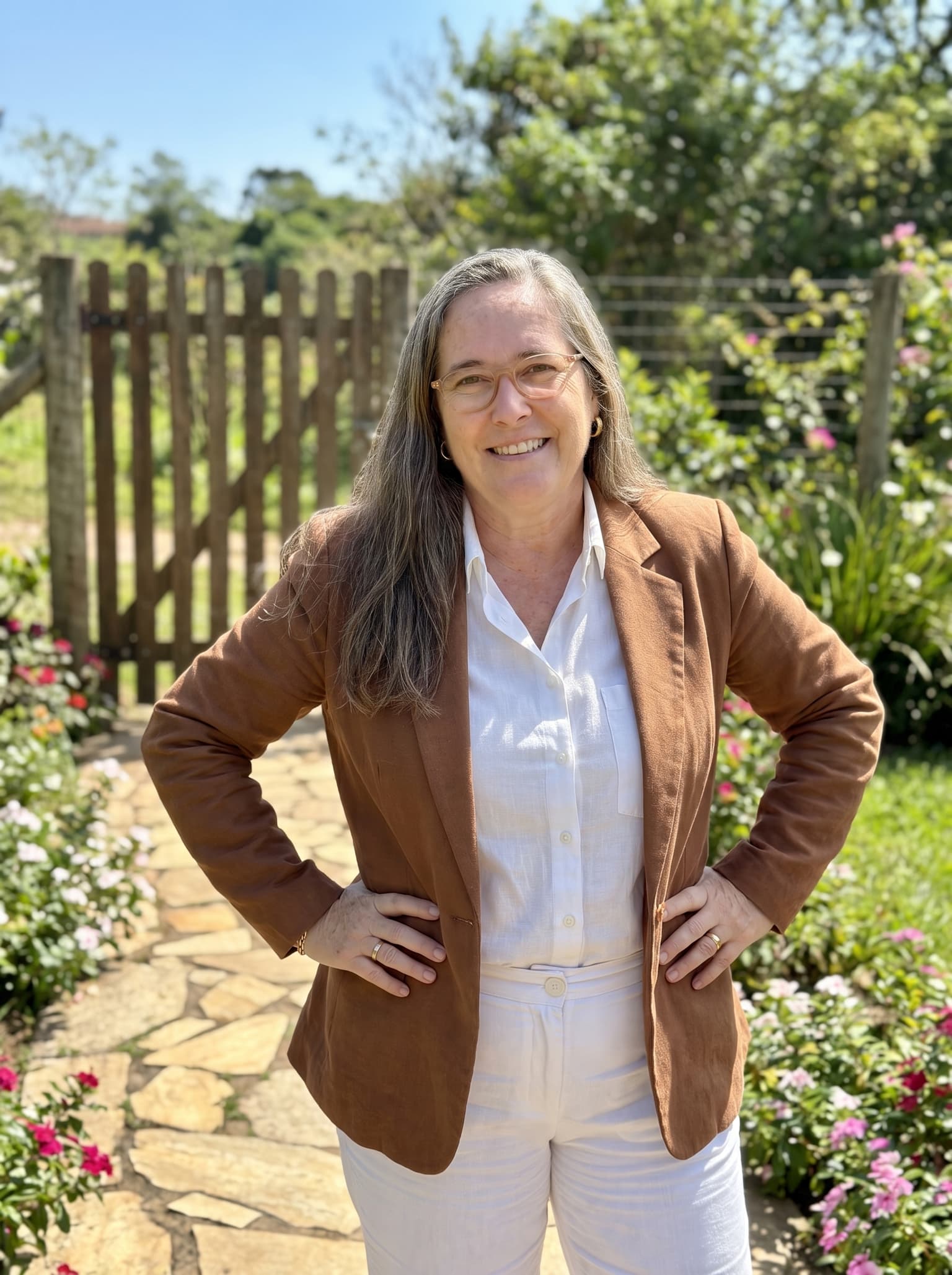 Giorgia Jaeger em um jardim, diante de uma cerca de madeira